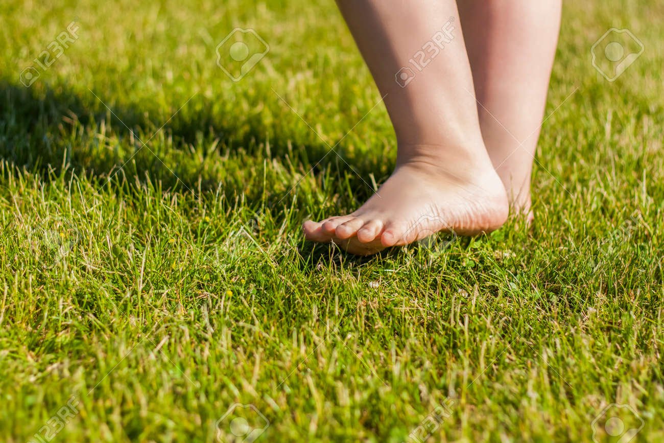171906964 los pies descalzos del nino sobre la hierba estoy feliz de caminar y jugar en el cesped en un clima
