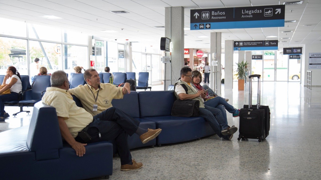 aeropuerto con viajeros en sala de espera
