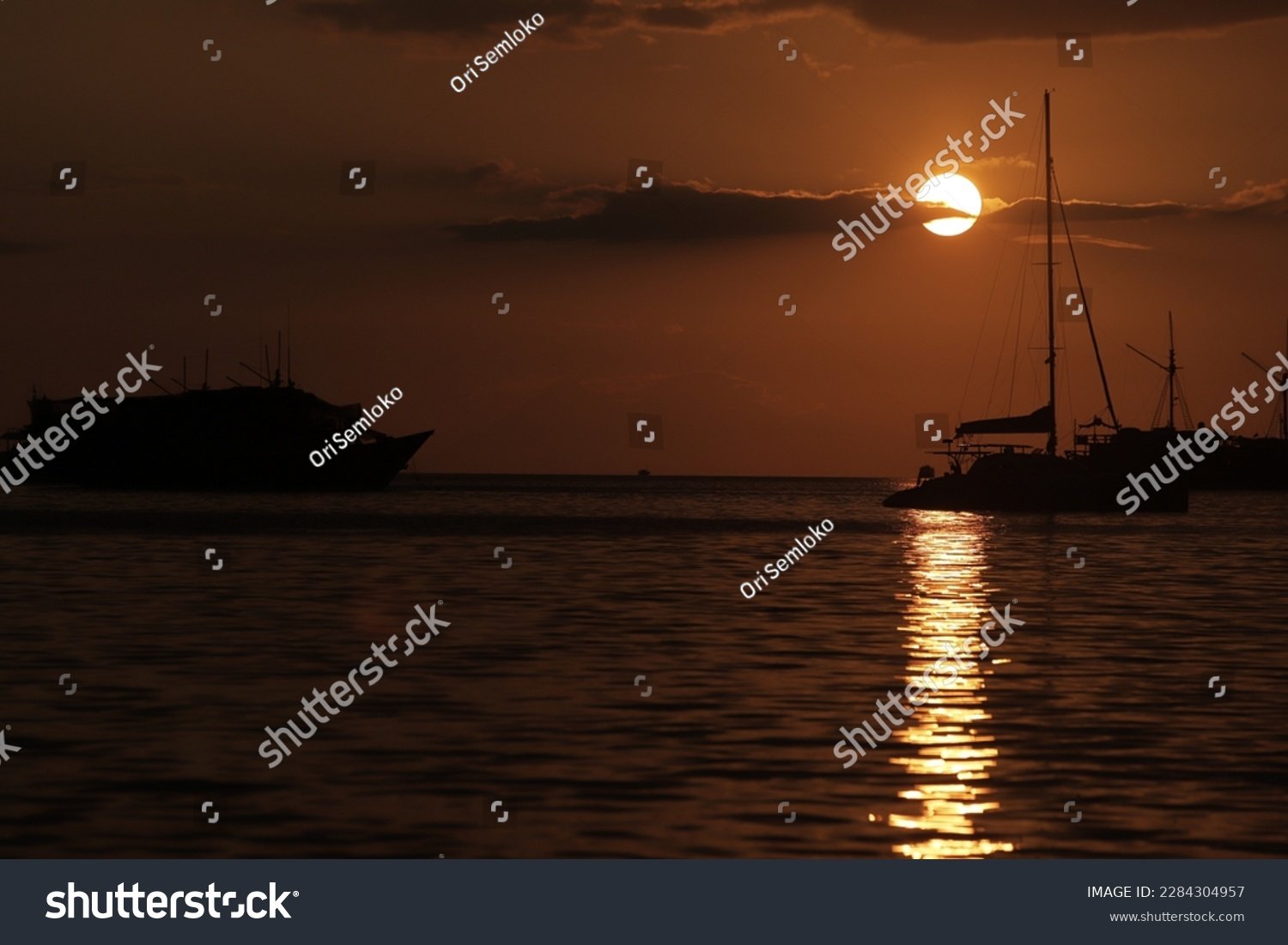 atardecer en labuan bajo con barcos