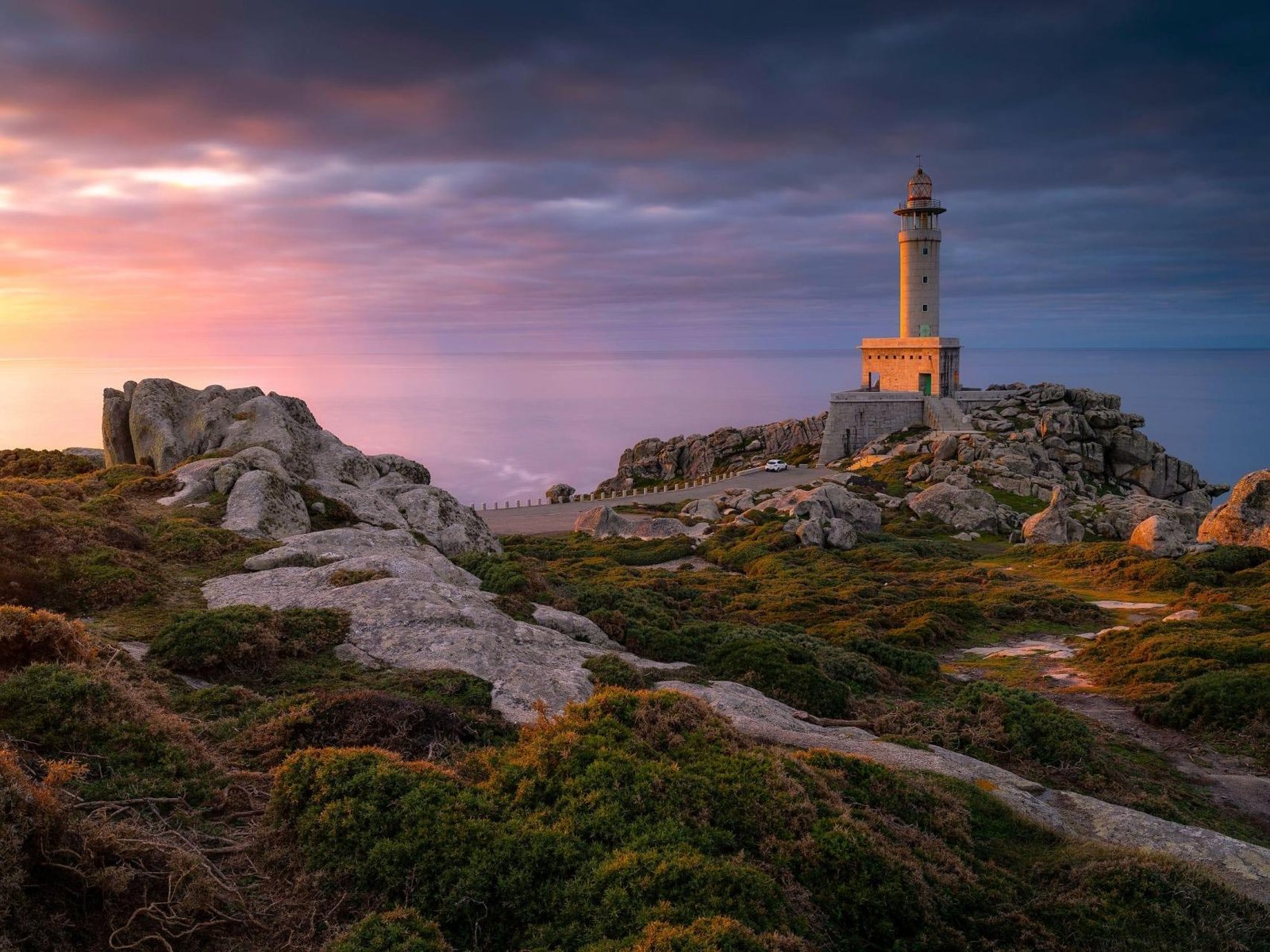 faro iluminado al atardecer en galicia
