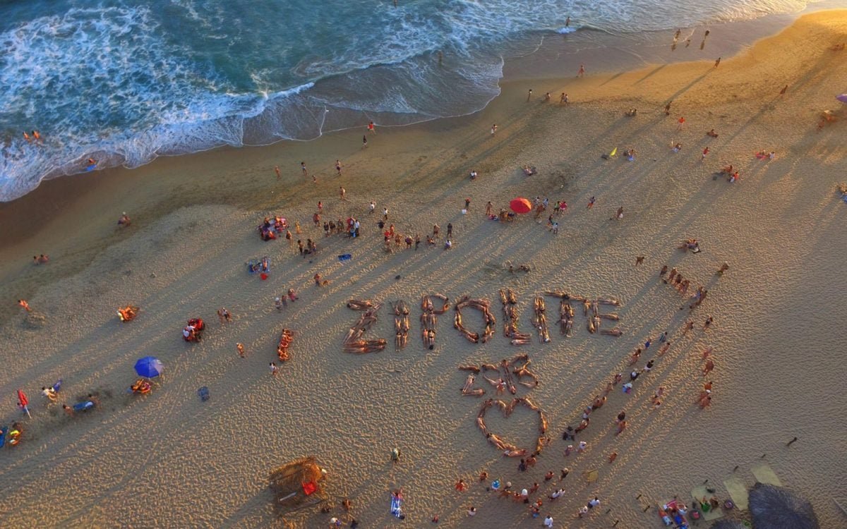 playa nudista con gente disfrutando al sol