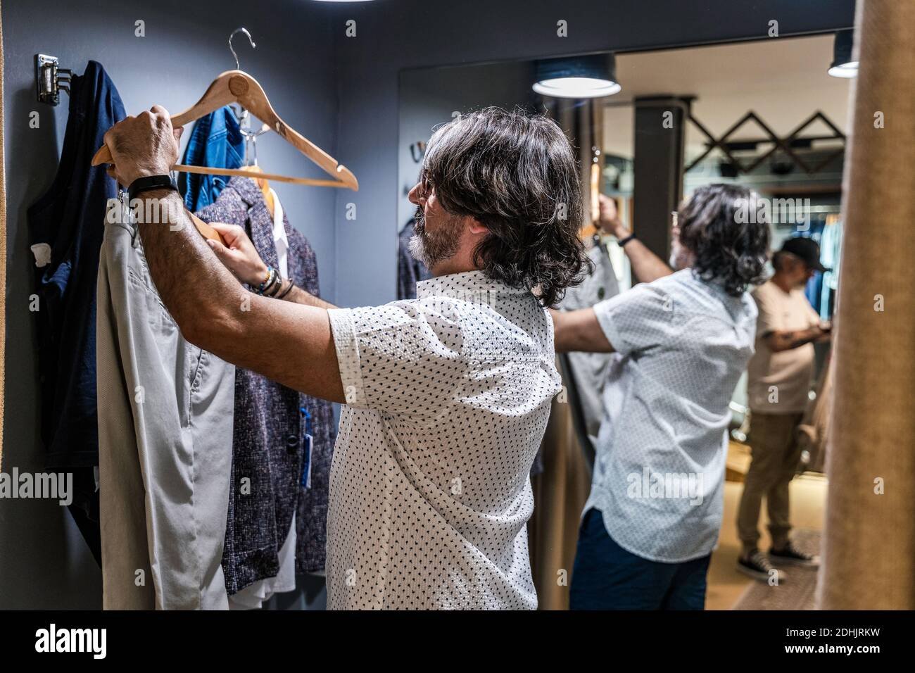 hombre probandose polos en tienda de ropa